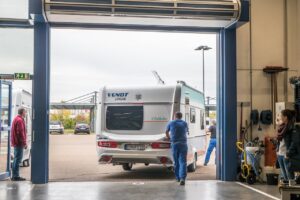 Wohnwagen wird aus der Werkstatt geschoben.