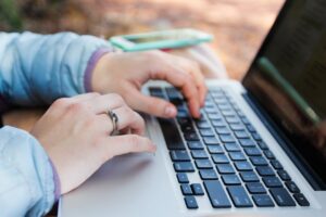 Finger tippen auf eine Laptoptastatur, Recherche im Internet