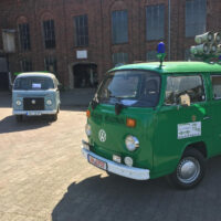 Zwei VW Bullis auf einem Hof