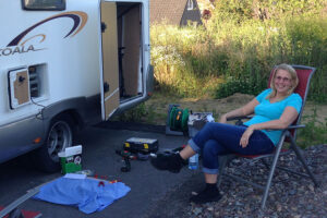 Bianca im Campingstuhl neben dem Camper