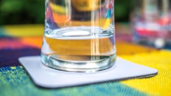 Ein Glas mit einem Magneten im Boden auf einem magnetischen Untersetzer