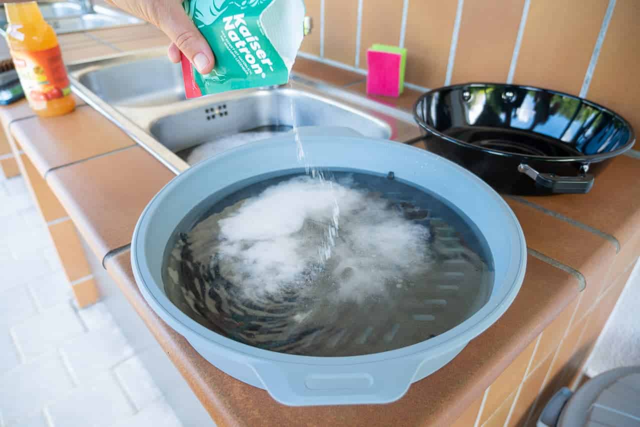Schmutzigen Grillrost mit Natron und Essig saubermachen.