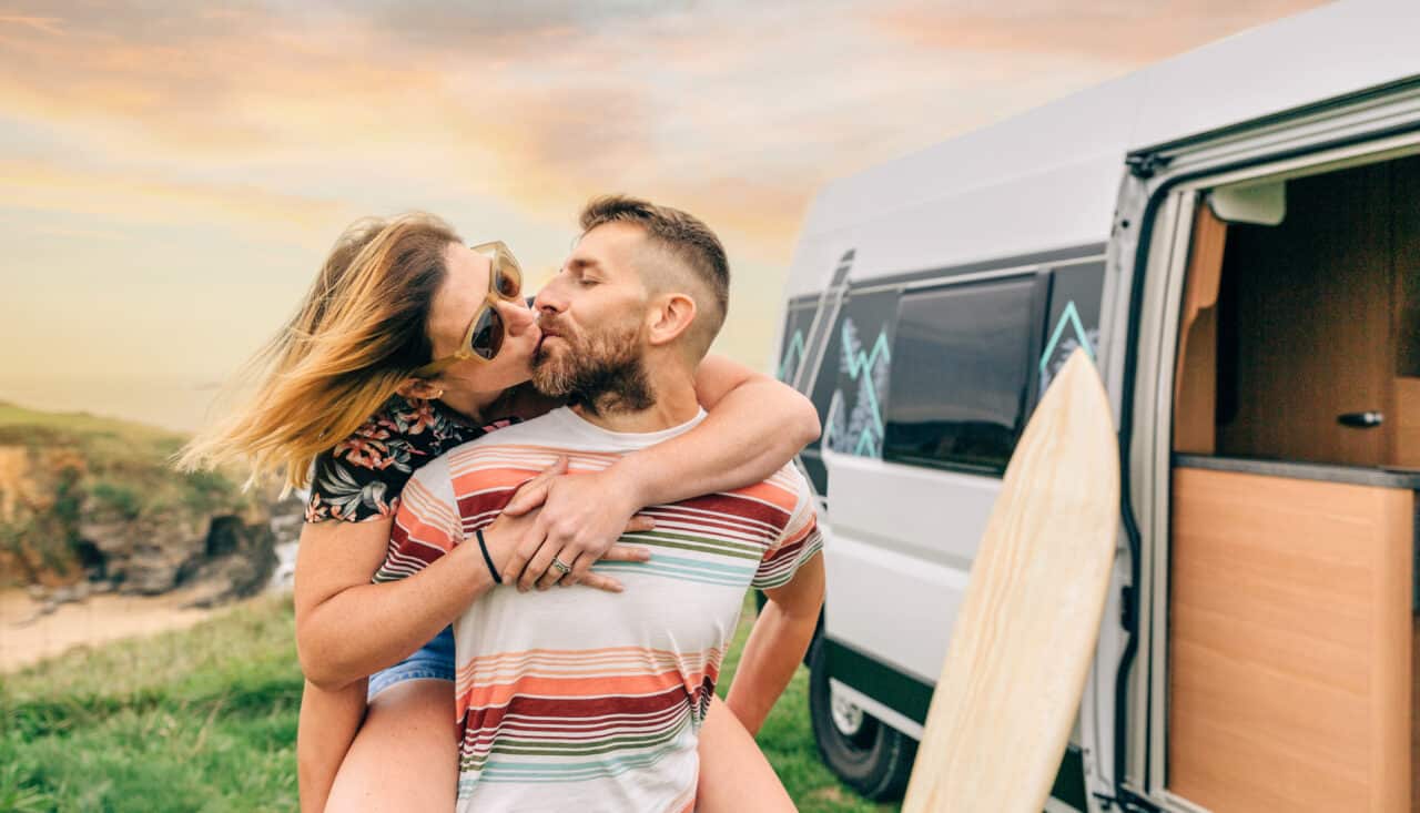 couple kissing piggybacking next to their camper v 2023 11 27 05 30 08 utc