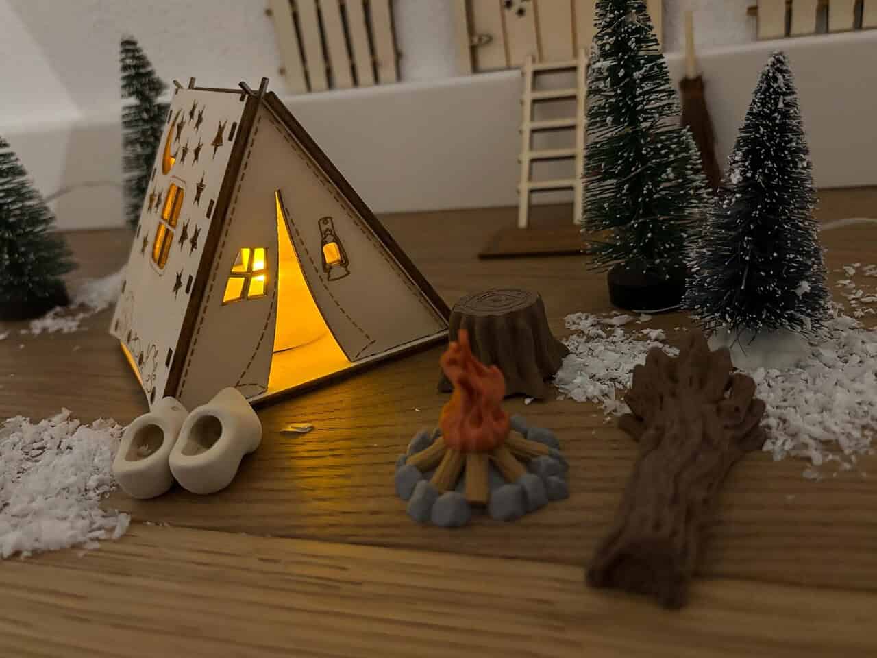 Weihnachten kommt! 6 süße Geschenkideen für Campingkinder und kleine Entdecker 3 Stimmungsvolle Camping-Deko mit kleinen Bäumen, Feuerstelle & Naturmaterialien, perfekt für Camperstyle.