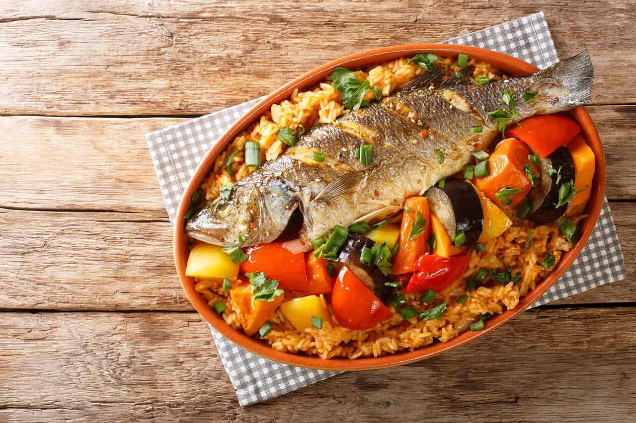 Mit dem Van ohne Allrad durch Westafrika: Ein Abenteuer zwischen Mauretanien, Senegal und Gambia 4 Frischer Fisch mit buntem Gemüse und Reis, perfekt für Campingküche, leicht zubereitet.
